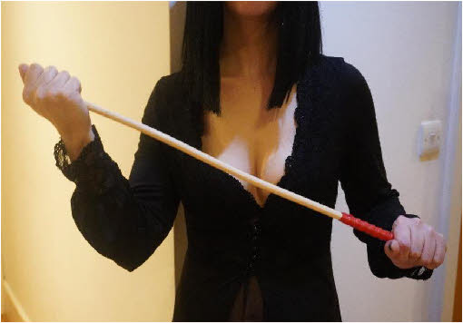 Strict London domme with spanking implement